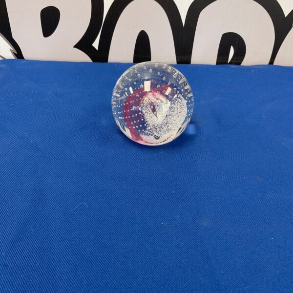 Close-up of a beautiful Caithness Champagne paperweight with swirling patterns.