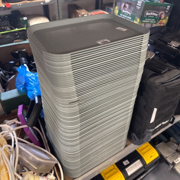 Stack of used Cambro catering trays for food service.