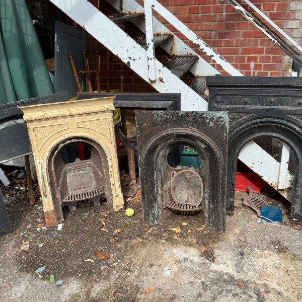 Lot of five antique cast iron fireplaces with ornate detailing.