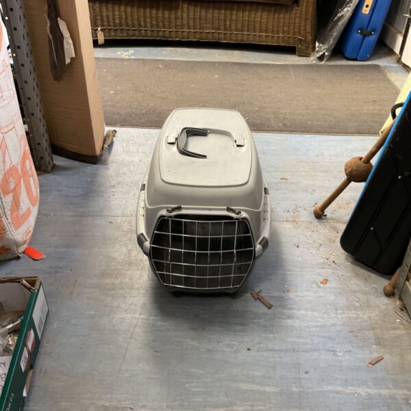 Grey plastic cat carrier with wire mesh door for pet travel.