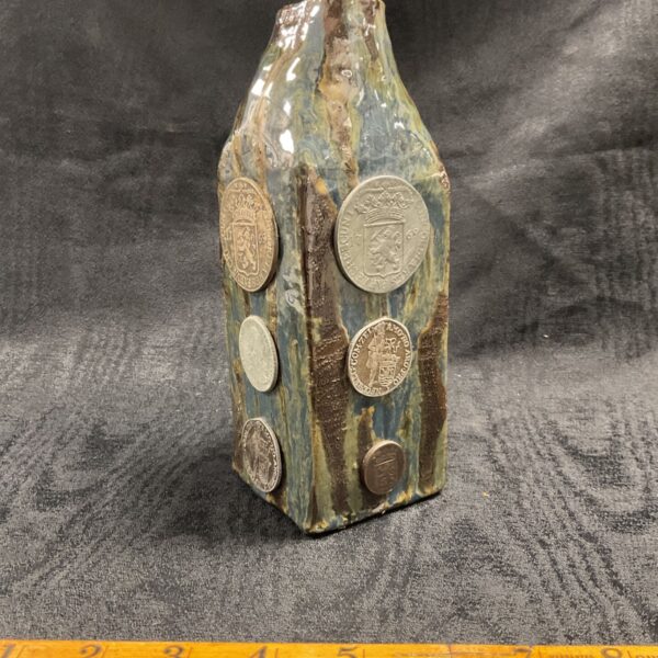 Ceramic coin vase with blue and brown glaze and embedded medalions.