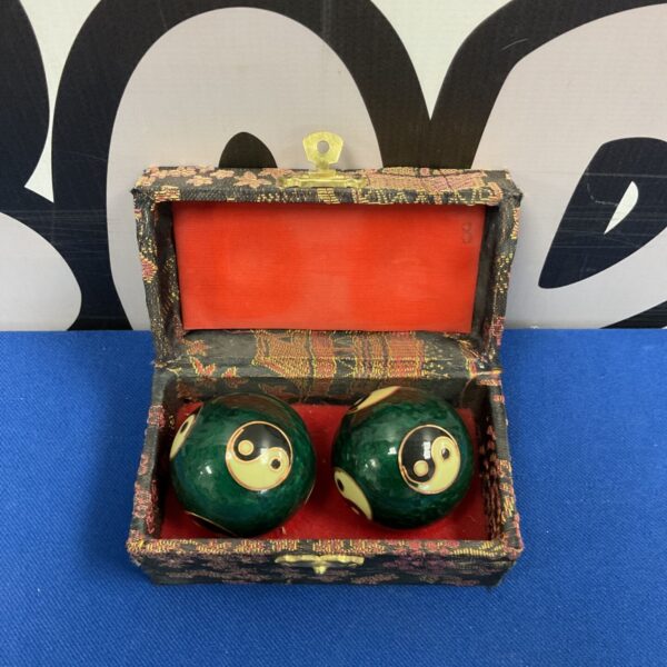 Antique Chinese baoding balls with yin yang symbols in a box.