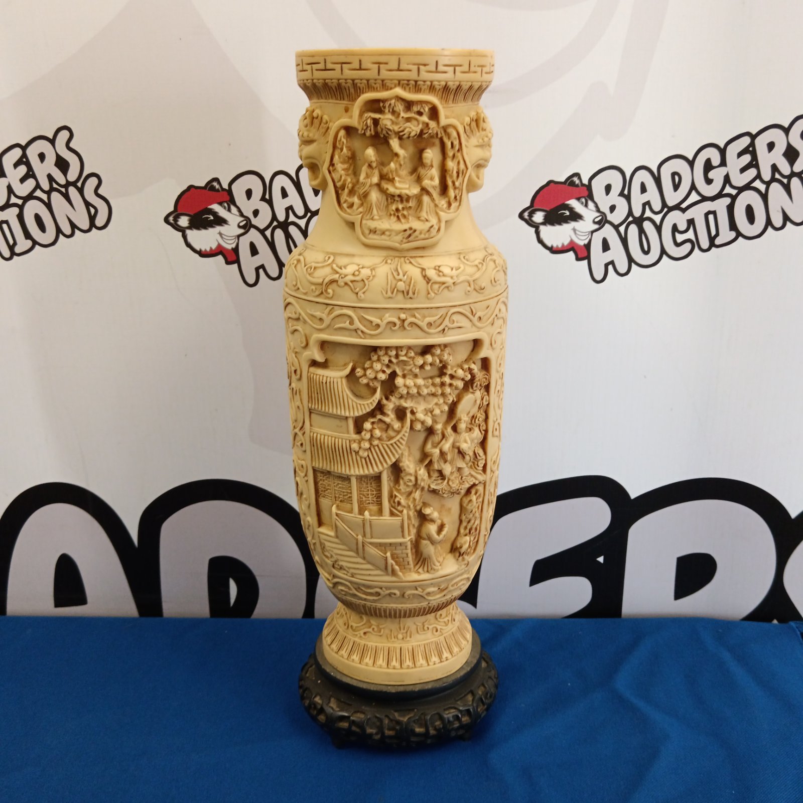 Detailed Chinese carved resin vase with landscape scene.