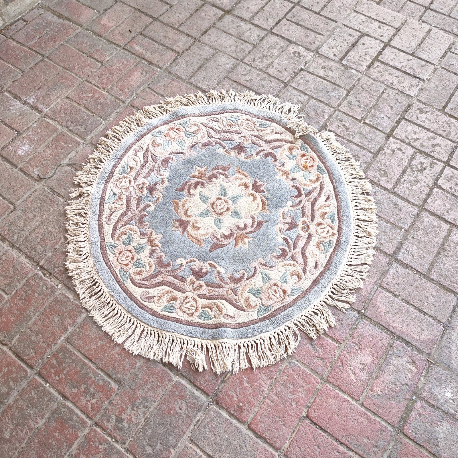 Vintage Chinese round rug with floral design and fringed edges.