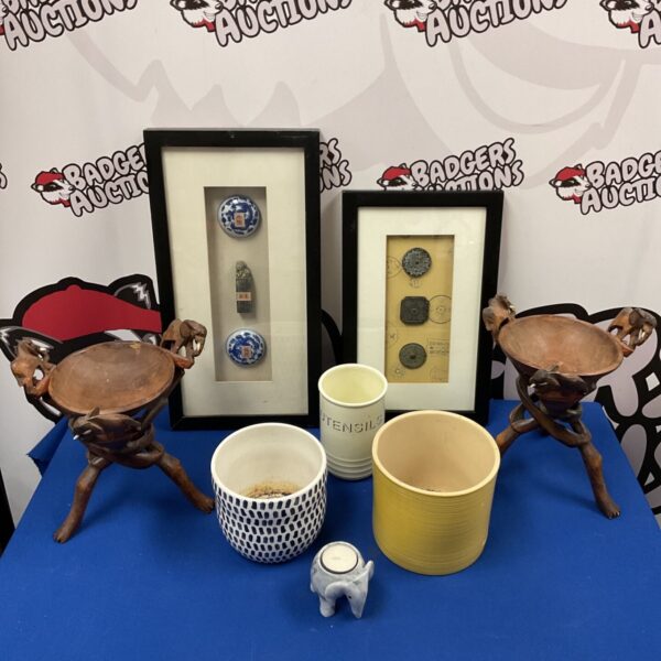 Framed Chinese tokens and antique pot lids with African elephant bowls.