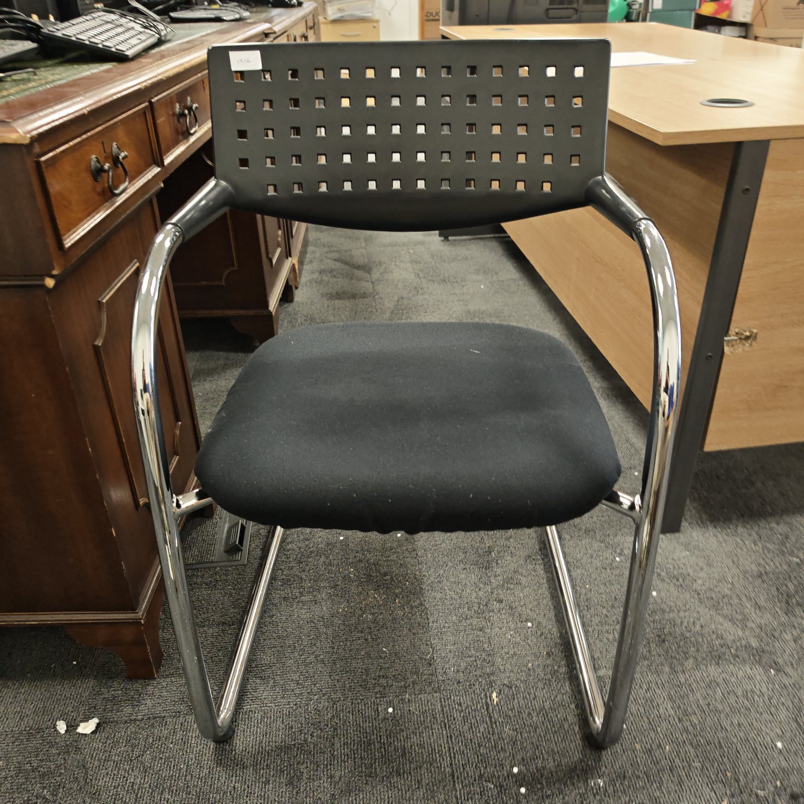 Chrome office reception chair with black seat and polished frame.