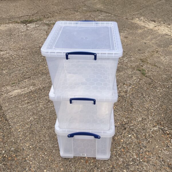 Lot of three clear plastic storage boxes for home organisation.