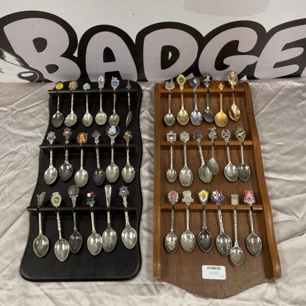 Silver plate collector spoons on a tiered display rack.