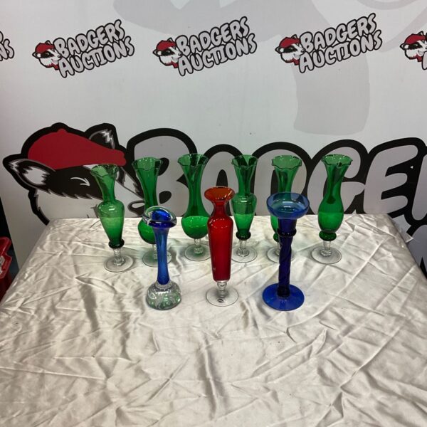 Collection of colourful vintage glass posy vases on display.