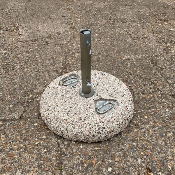 Grey concrete parasol base for outdoor garden use.
