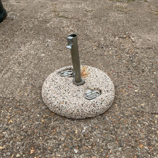 Grey concrete parasol base for garden umbrellas.