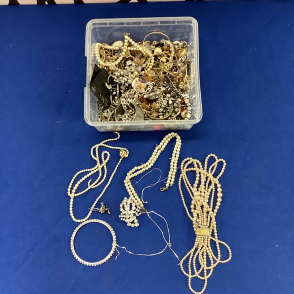 Mixed lot of vintage costume jewellery in a plastic box.