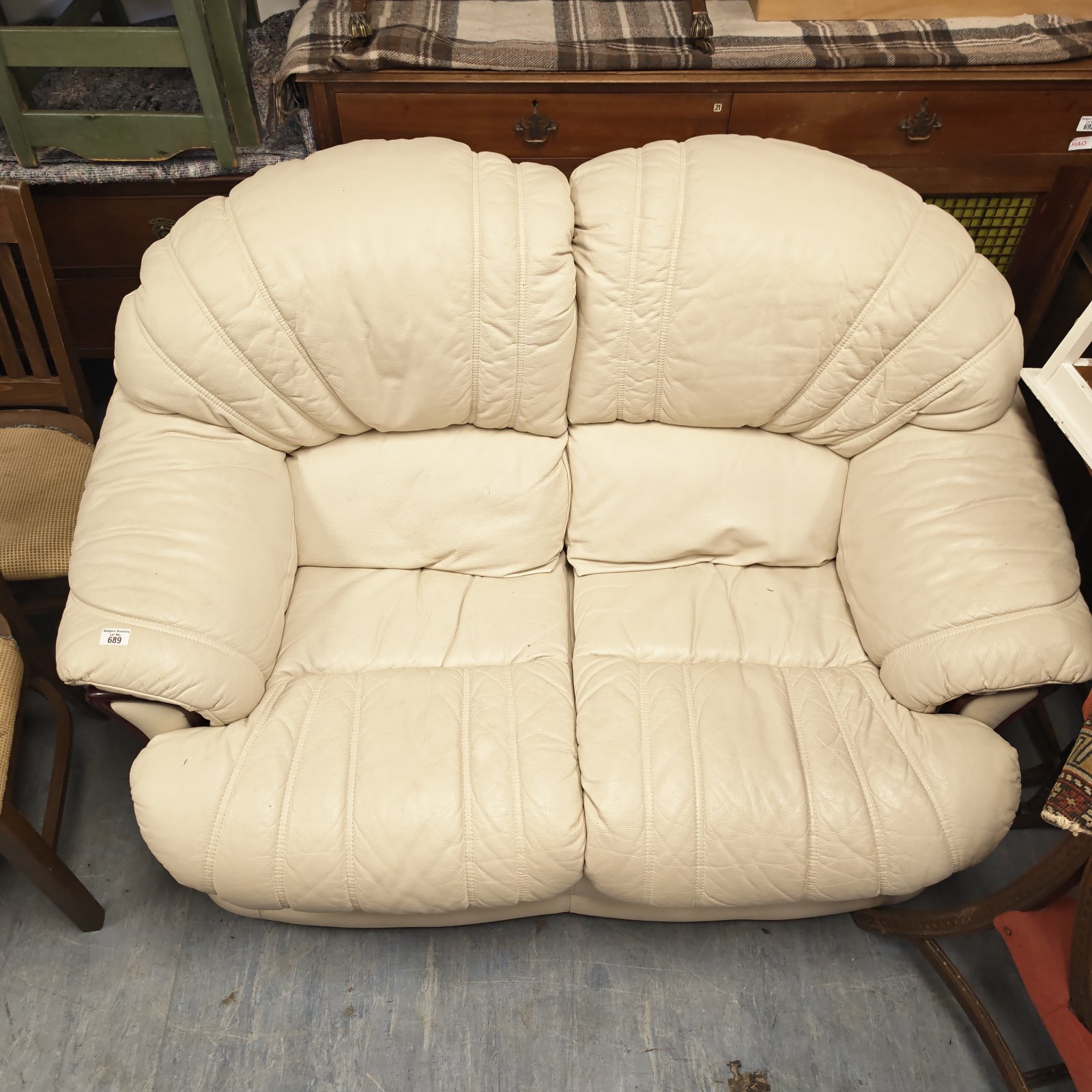 Cream leather two-seater sofa with a vintage 1970s style.