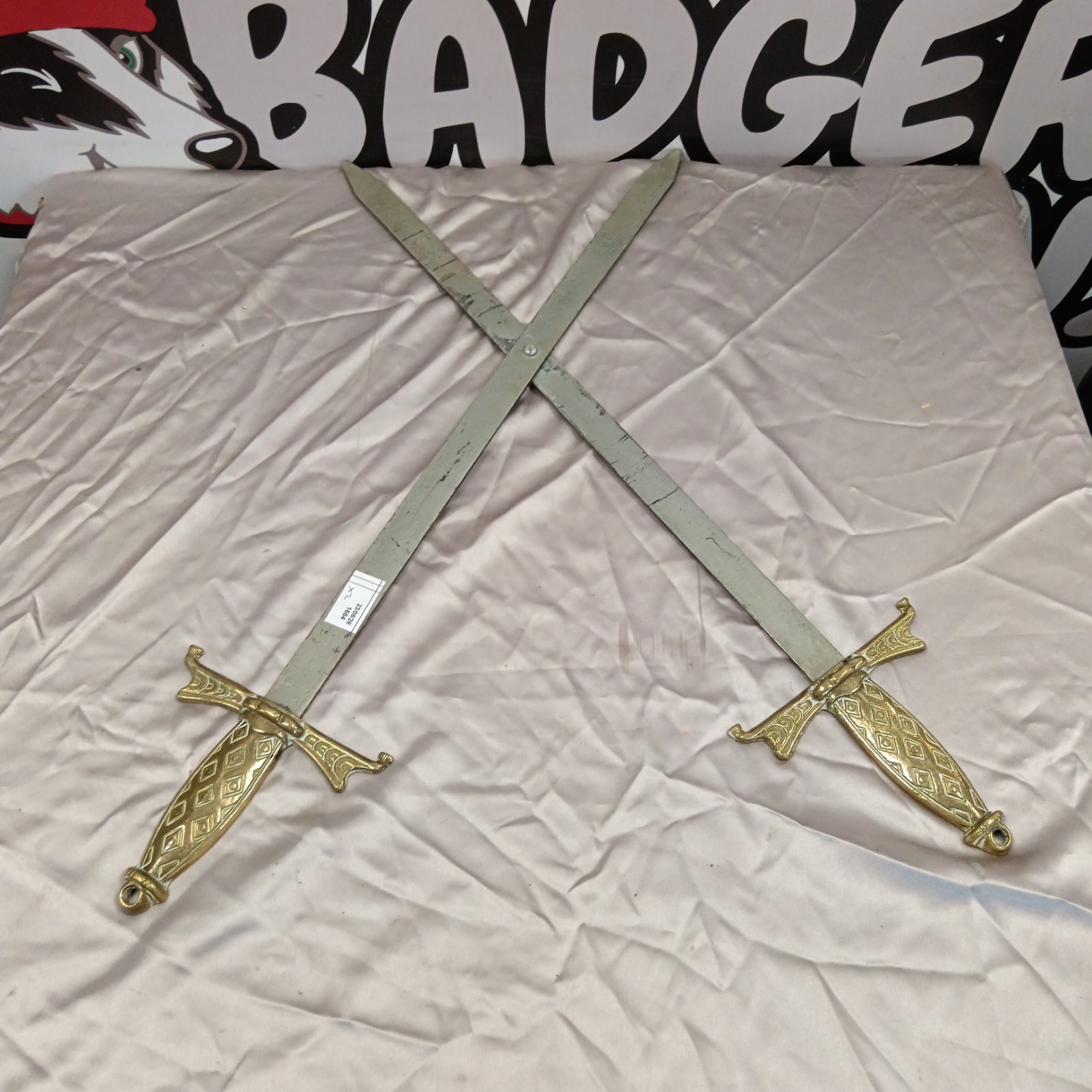 Vintage crossed swords wall decor with ornate gold hilts.