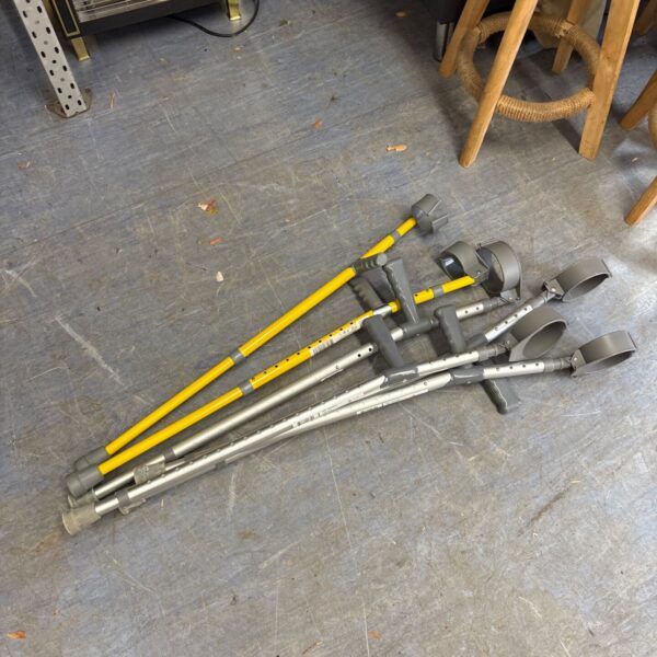 Pair of adjustable grey and yellow crutches for mobility support.
