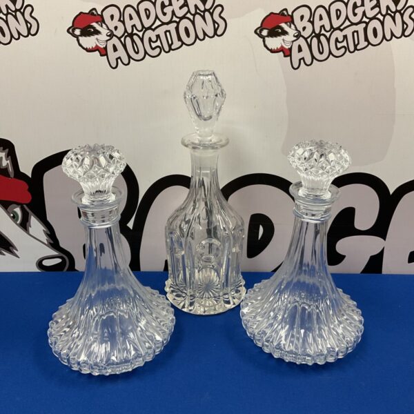 Vintage crystal decanter set with stoppers, elegant glassware.