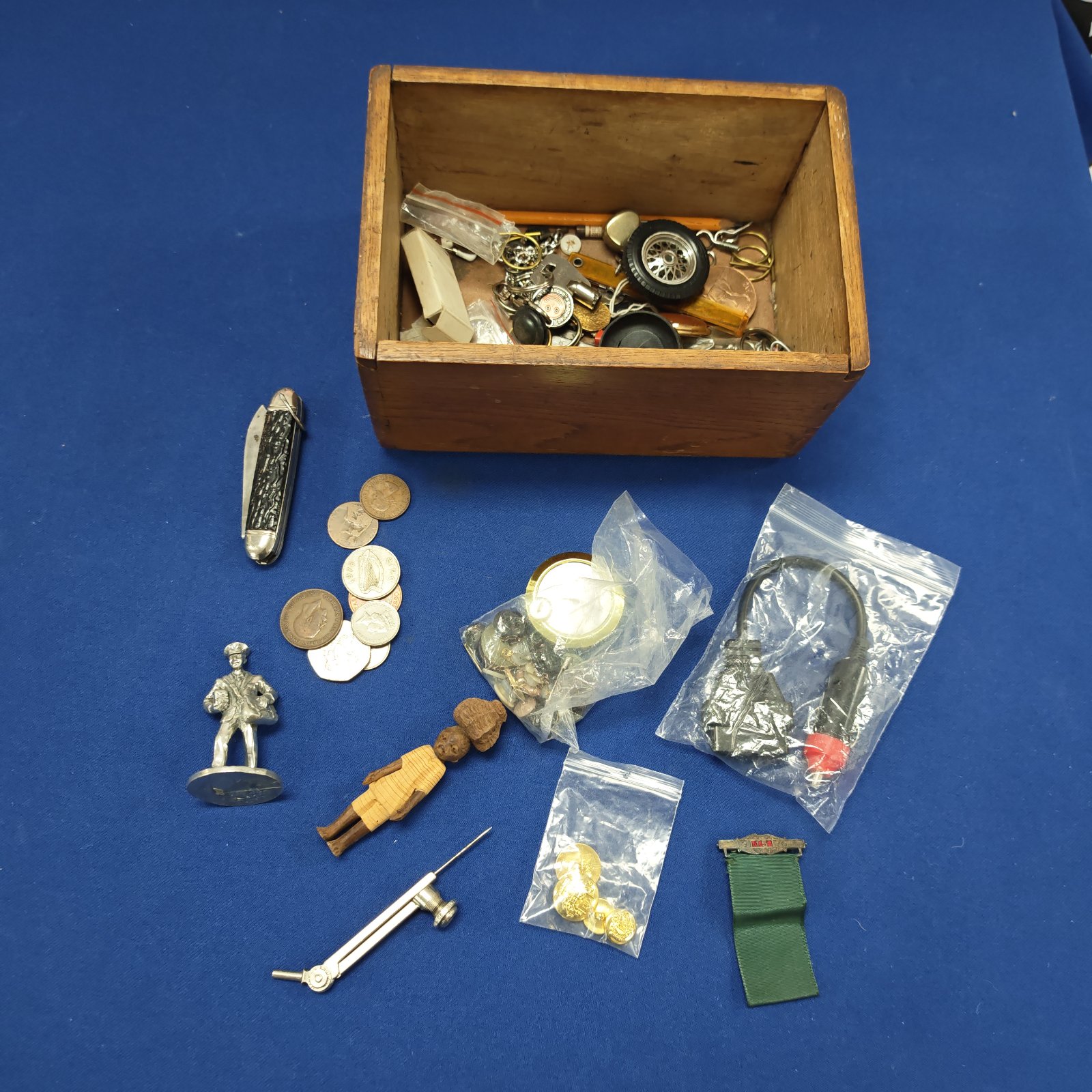 Vintage curios box filled with buttons, coins and keyrings.