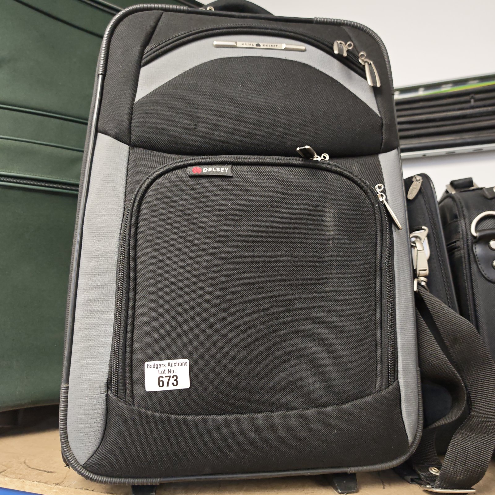 Dark grey Delsey wheeled suitcase with extending handle.