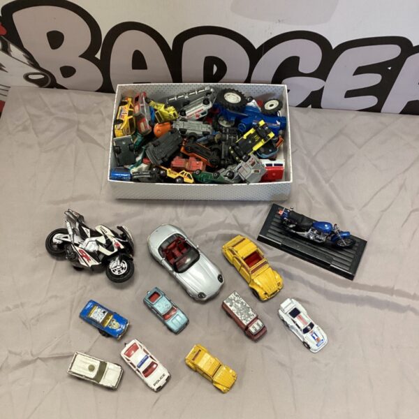 Assorted diecast model cars in a box, including Corgi and Matchbox vehicles.