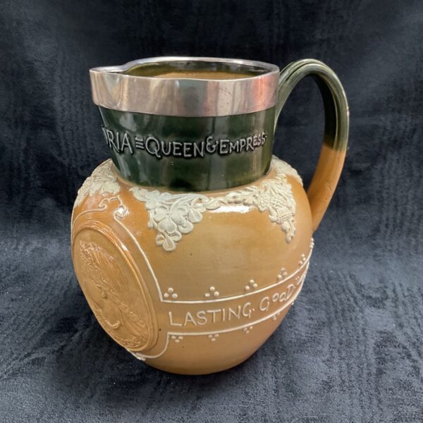 Antique Doulton Lambeth saltglaze jug with silver rim and Victorian inscription.