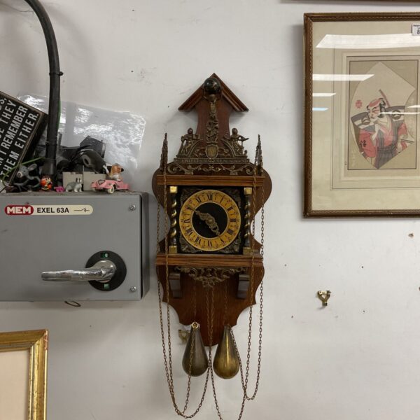 Antique Dutch Zaanse wall clock with weights, a vintage timepiece.