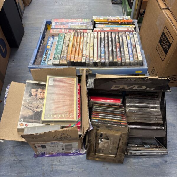 Mixed lot of DVDs, VHS tapes, and CDs for collectors.