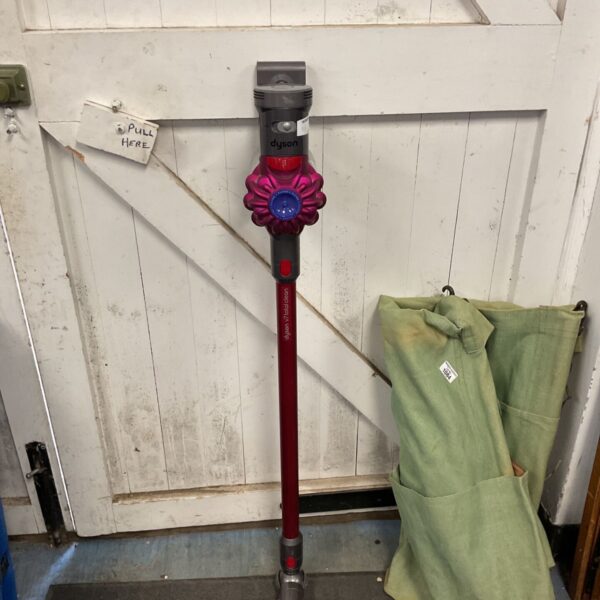 Red Dyson v7 Totalclean cordless stick vacuum cleaner on display.