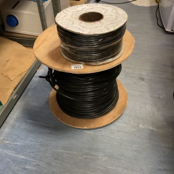 Large wooden drum loaded with black electrical cable for wiring projects.