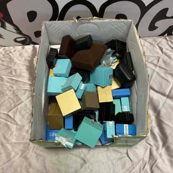 A box filled with various empty jewellery boxes for rings and earrings.