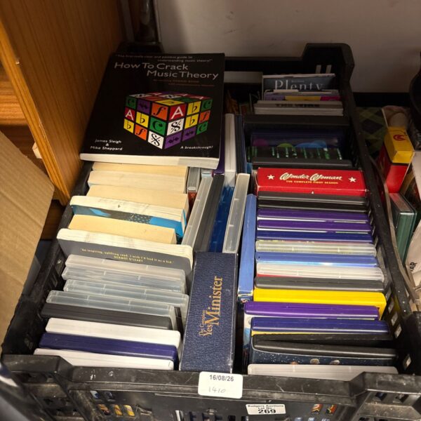 Crate filled with mixed entertainment including Xbox games and Harry Potter books.