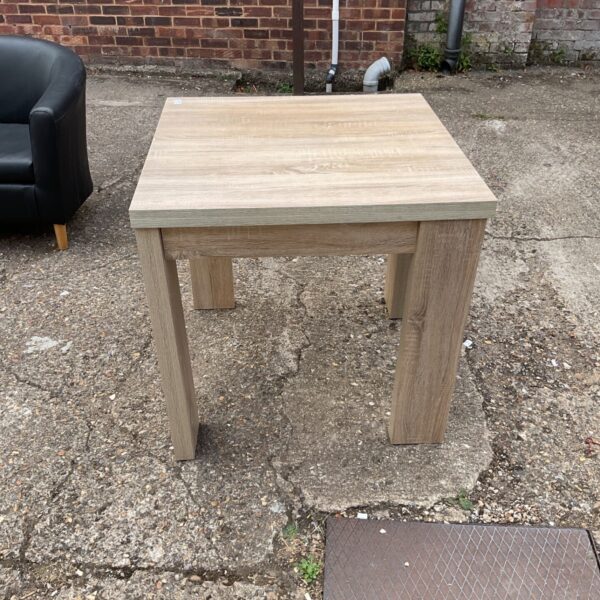 Light oak extending dining table in a garden setting.