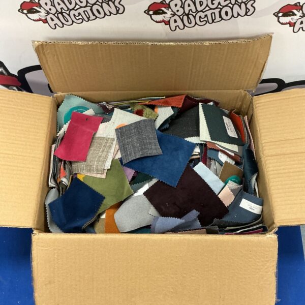 Box of assorted fabric samples for crafting and design projects.