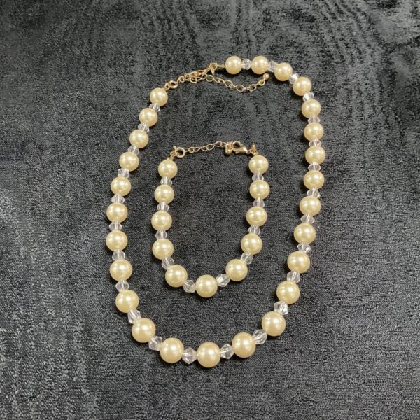 Faux pearl and crystal necklace and bracelet set displayed.