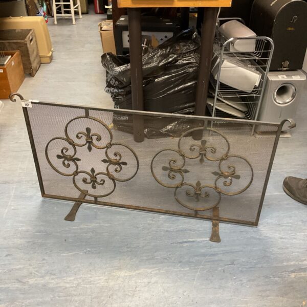 Antique wrought iron fire screen with fleur de lis design for fireplace.