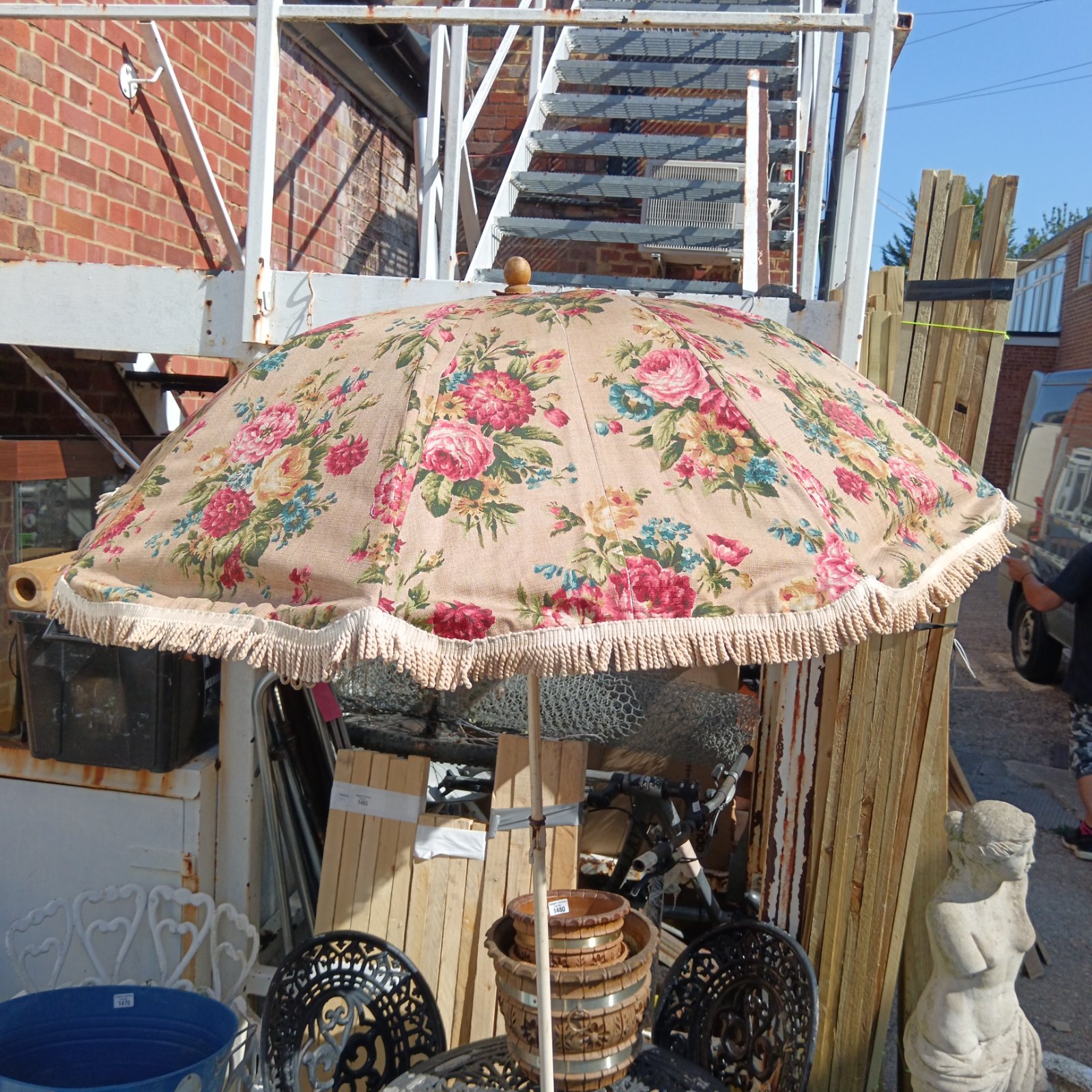 Vintage floral garden parasol providing shade in a garden setting.