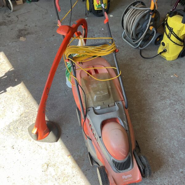 Orange and black Flymo Chevron 34VC electric lawnmower with power cable.