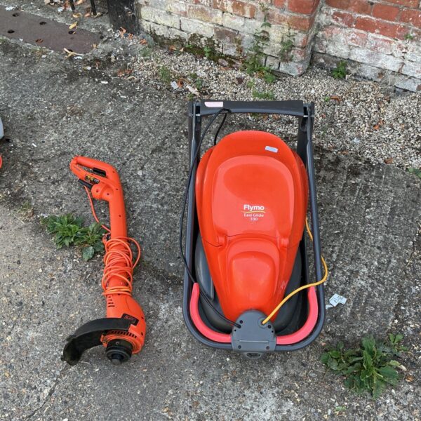 Red Flymo Easy Glide 330 electric lawnmower in used condition.