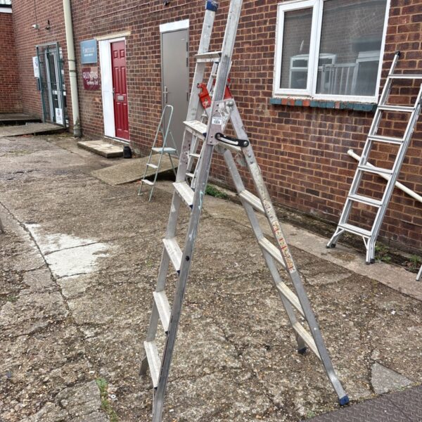 Used folding aluminium ladder leaning against a brick wall.