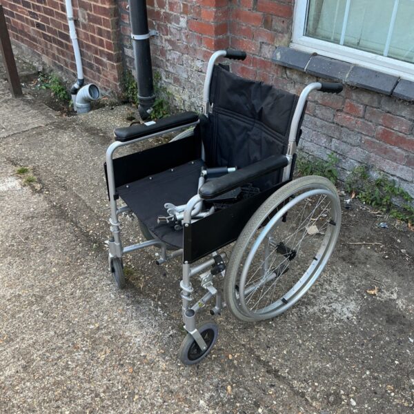 Silver folding wheelchair with spoked wheels, a mobility aid.