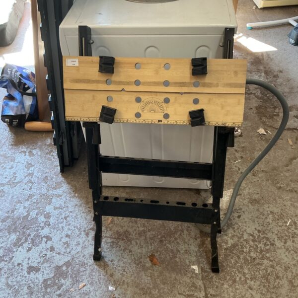 Portable folding workbench table with clamping jaws and ruler scale.
