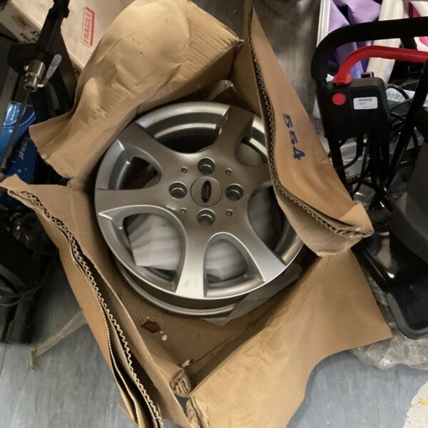 Silver Ford alloy wheel with five spokes, showing signs of use.