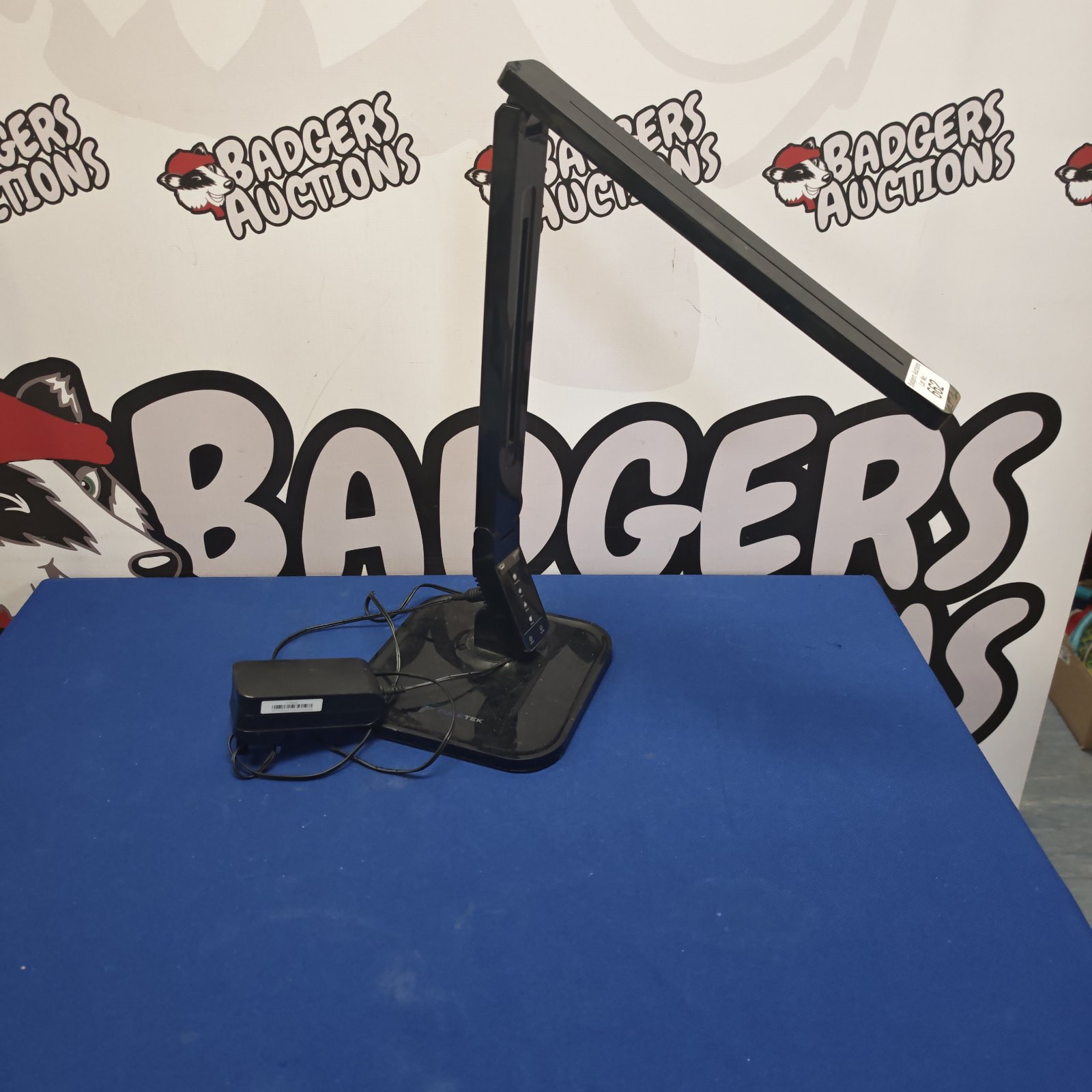 Black Fugetek LED reading lamp on a desk.