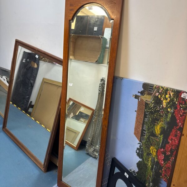 Antique full length mirror with bevelled glass and dark wooden frame.