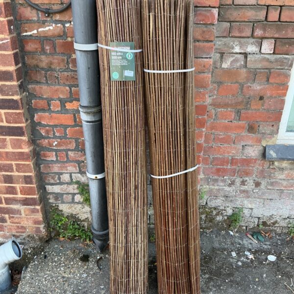 Two rolls of natural wicker garden screen fencing for garden privacy.