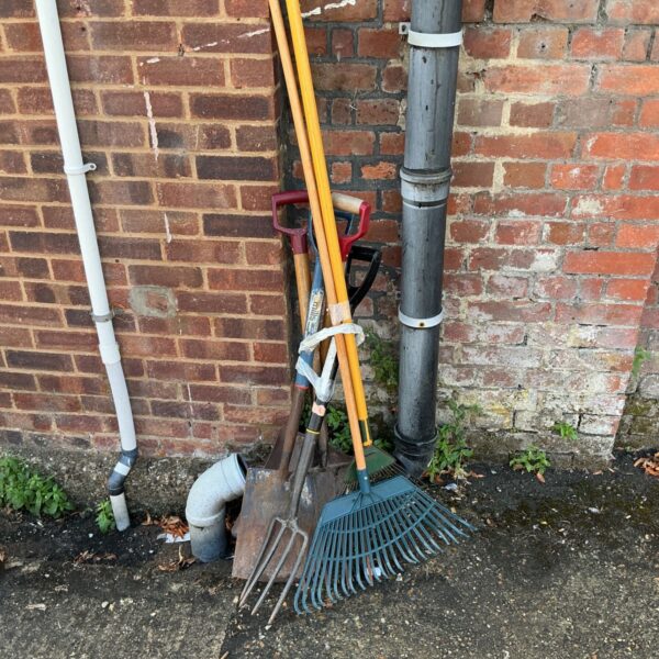 Job lot of used garden tools including shovels and rakes.