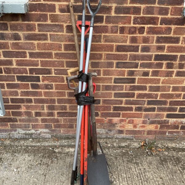 Job lot of used garden tools including shovels and rakes.