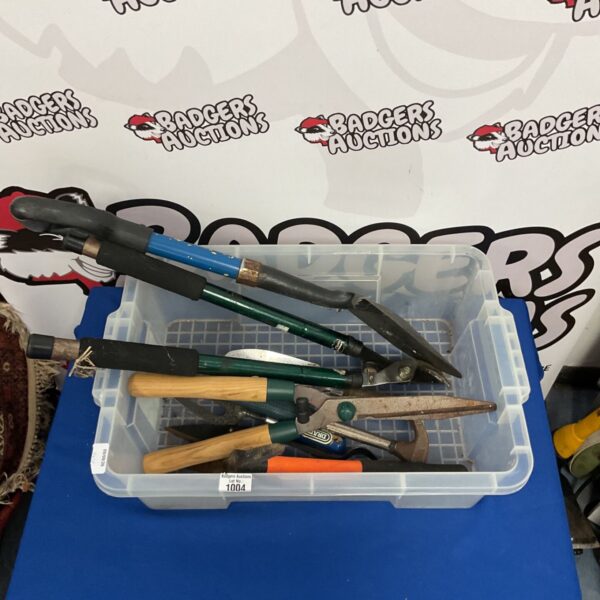 Lot of used garden tools including a shovel and shears.