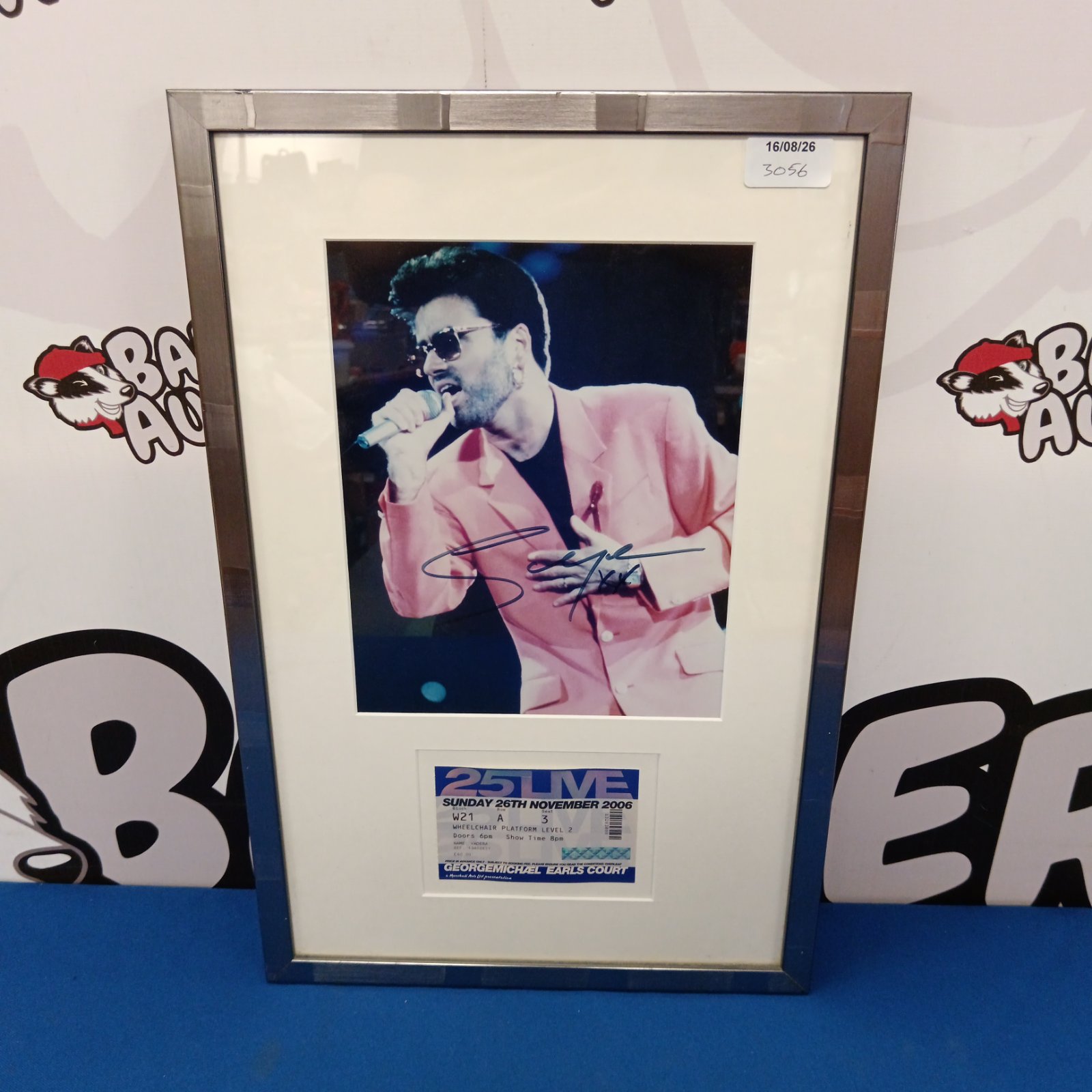 Signed George Michael photograph with concert ticket, a collectible music item.