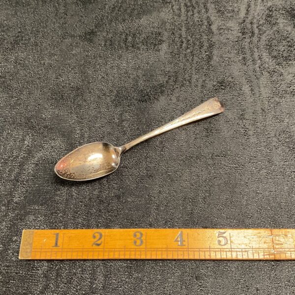 Antique Georgian silver teaspoon on a dark surface.