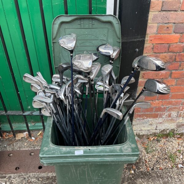 Full view of a job lot of vintage golf clubs.